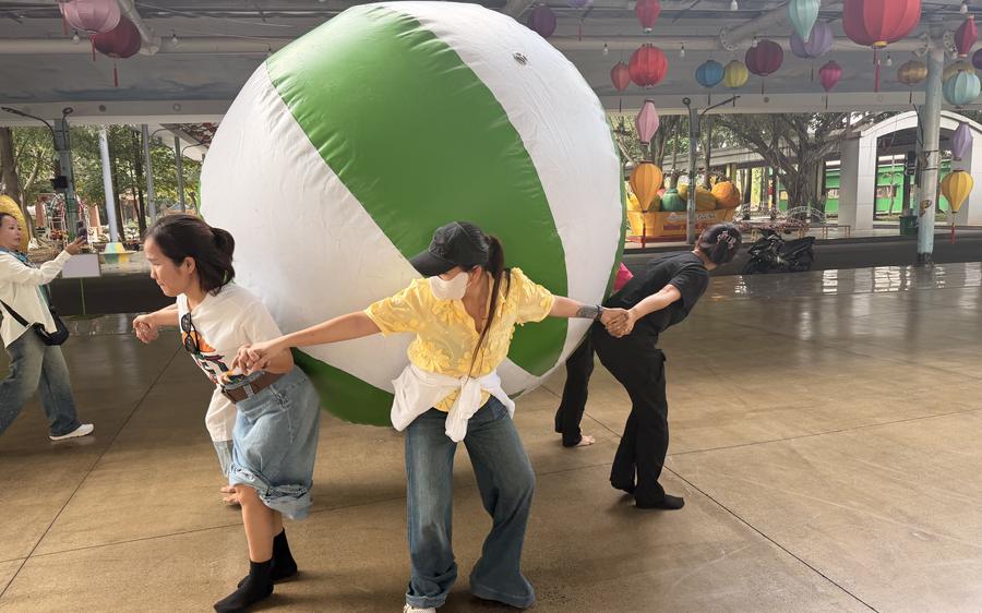 Hai bạn cùng ôm quả bóng lớn trong trò chơi đồng đội