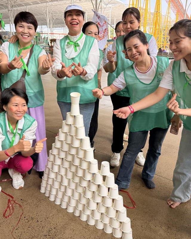 Nhóm bạn cười rạng rỡ bên tháp cốc vừa hoàn thành